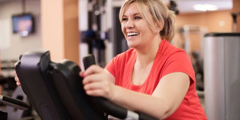 Frau trainiert an einem Fitnessgerät.