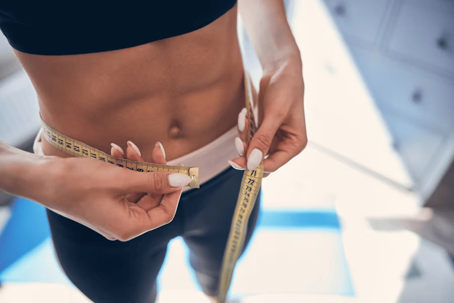 Frau misst ihren BMI, der durch ihre Muskeln verfälscht wird.