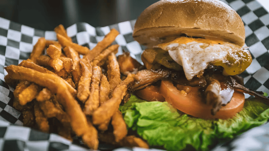 Ungesundes Mittagessen, einem Burger als Hauptspeise und Pommes mit viel Salz als Beilage.