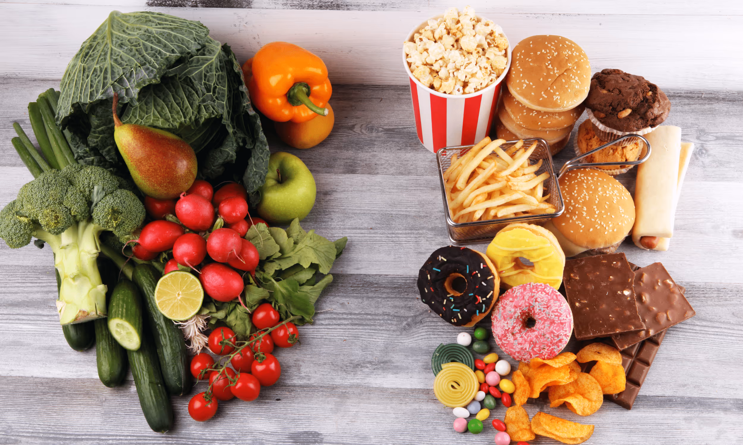 Gemüse und Obst neben Fast Food und Süßigkeiten.